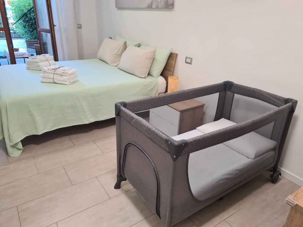 Culla da viaggio nella camera matrimoniale di Casa dell'Ulivo, accanto al letto
